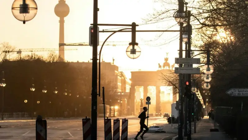 A lone runner passes the Brandenburg Gate at sunrise. This iconic Berlin landmark is a must-see, no matter how many days in Berlin you have.